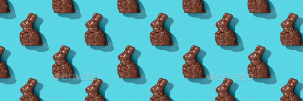 Chocolate Easter Bunny on blue background pattern, flat lay - Stock Photo - Images