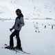Girl dressed in a ski suit and helmet  stands on ski with ski poles against backdrop of ski slope - PhotoDune Item for Sale