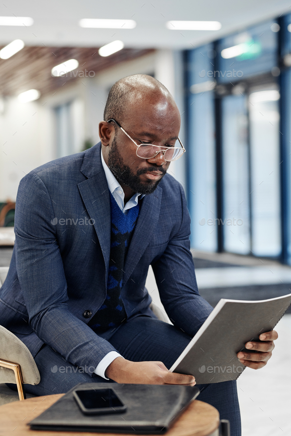 Businessman reading a report before meeting - Stock Photo - Images