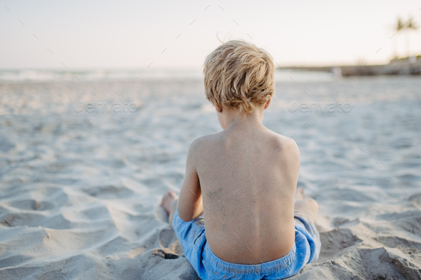 Little boy playing on the beach, rear view. - Stock Photo - Images