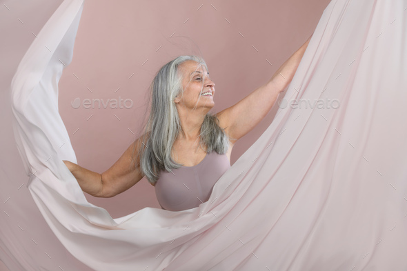 Portrait of smiling senior woman in studio. - Stock Photo - Images
