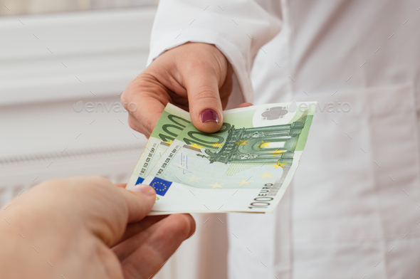 Female doctor getting some euros from her customer, payment. - Stock Photo - Images