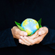 Young woman holding small planet in hands against black background. Ecology, environment and Earth - PhotoDune Item for Sale