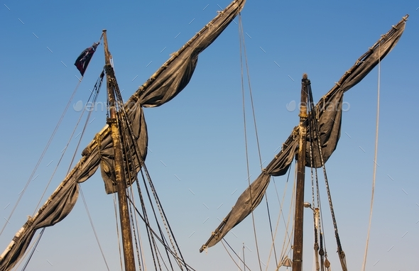 Dark masts of a ship with the sky in the background Stock Photo by wirestock