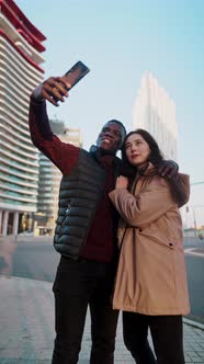 Loving Multiracial Couple Taking Self Portrait in City alt