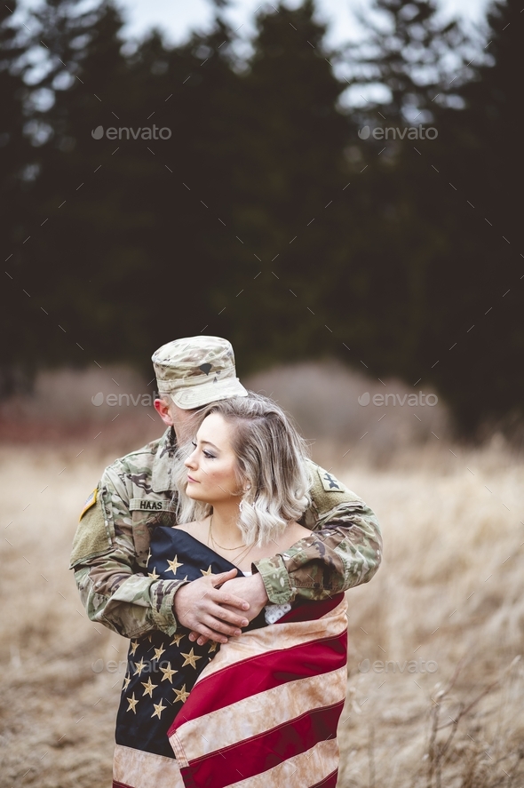 Shallow focus vertical shot of an American soldier hugging his wife