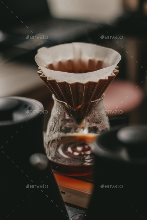 Soft focus of a pour over coffee setup using cone dripper and glass