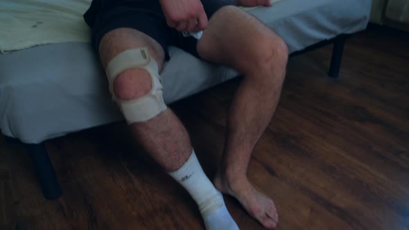 A Man Removes a Knee Brace After Playing Active Sports Such As Football Tennis Volleyball Basketball