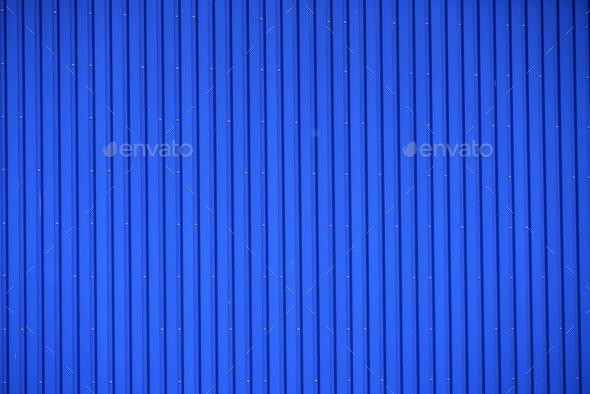 Blue fence made of a profiled sheet on a stone wall