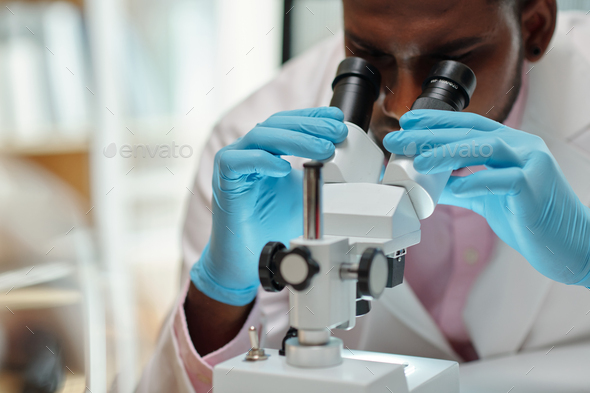 Medical Student Looking through Microscope - Stock Photo - Images