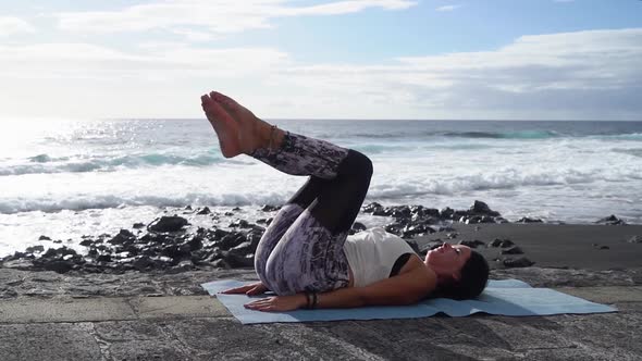 Woman in Sport Clothes Practicing Yoga and Meditating on Beach in Morning alt