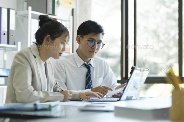 Businesspeople are working by discuss and analyses their project by using laptop and graphs. - Stock Photo - Images