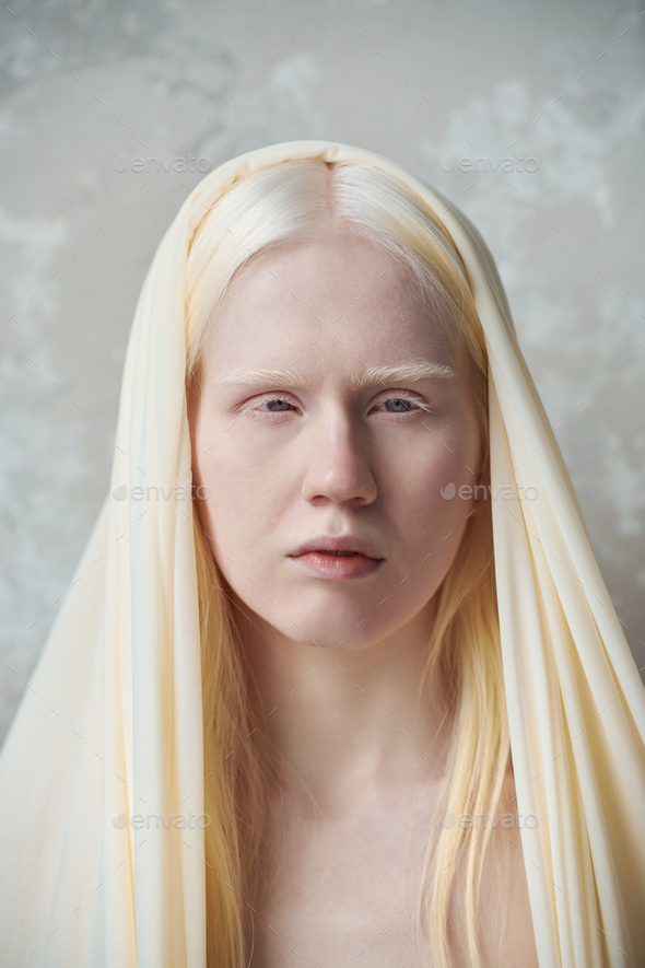 Young serene albino woman with white cover on head
