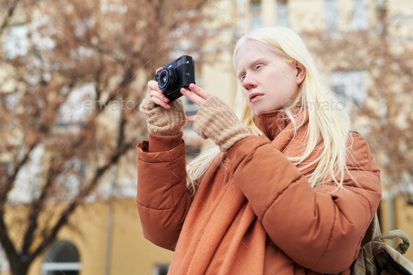 Young albino woman with photocamera taking photos of autumn city - Stock Photo - Images