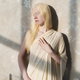 Serene albino girl in white attire standing by wall and enjoying sunlight - PhotoDune Item for Sale