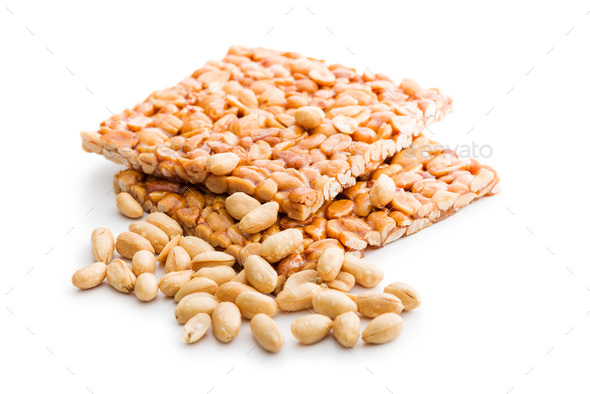 Sweet peanut brittle. Tasty peanuts in caramel isolated on white background.