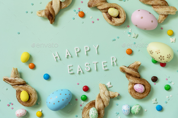 Colors Easter eggs with Easter rabbit-shaped buns puff pastry with cinnamon. - Stock Photo - Images