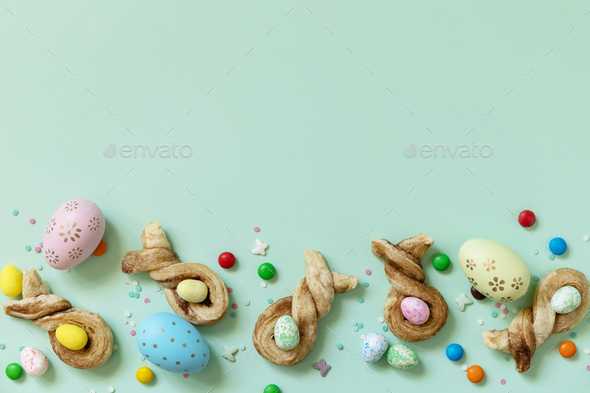 Colors Easter eggs with Easter rabbit-shaped buns puff pastry with cinnamon.  - Stock Photo - Images