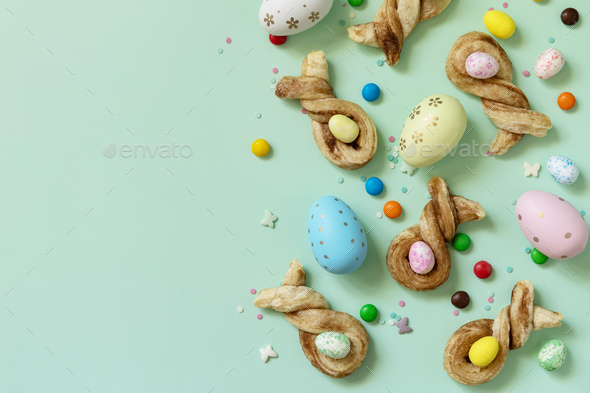 Happy Easter Holidays. Colors Easter eggs with Easter rabbit-shaped buns puff pastry with cinnamon.  - Stock Photo - Images