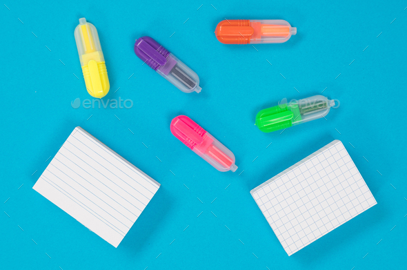 Five multicolored text markers and two piles of white scratch papers on  azure background cutout Stock Photo by traimakivan