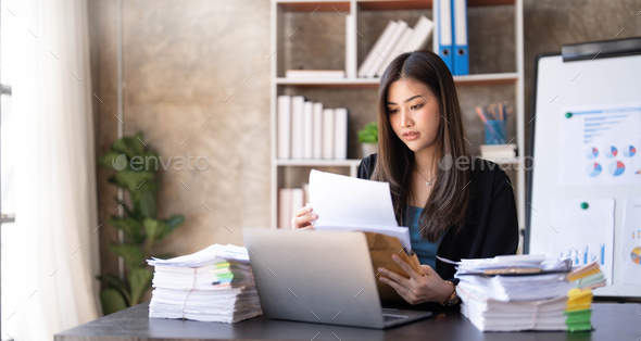 Young Asian businesswoman working on laptop computer, stressed has a headache and thinks hard from - Stock Photo - Images