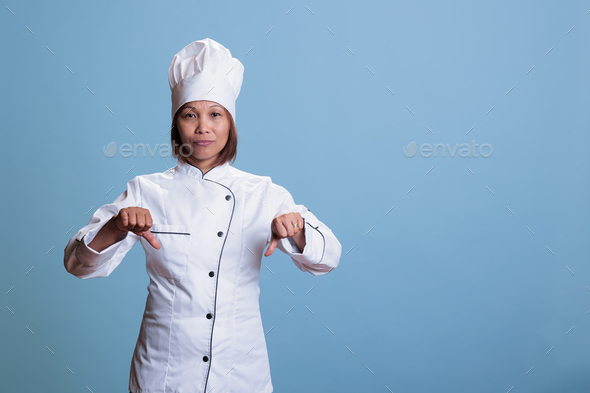 Elderly cook woman wearing kitechen uniform doing disapproval sign