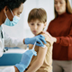 Black female doctor vaccinating small boy at medical clinic. - PhotoDune Item for Sale