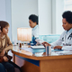 Black female doctor talking to mother and son during medical appointment at pediatrician&#39;s office. - PhotoDune Item for Sale