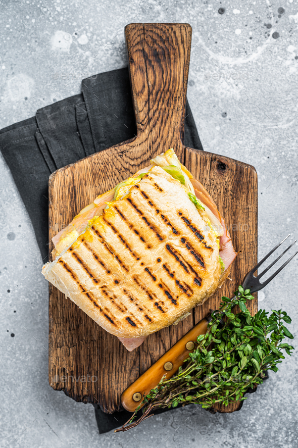 Toasted Panini sandwich with Prosciutto ham and cheese. Gray background. top view Stock Photo by