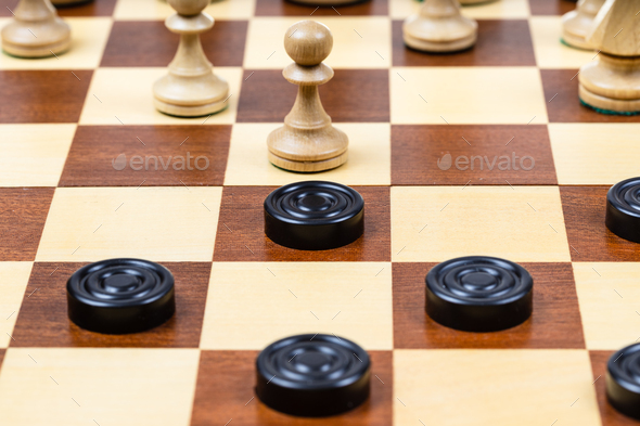 pawn and checkers piece in center of board closeup - Stock Photo - Images