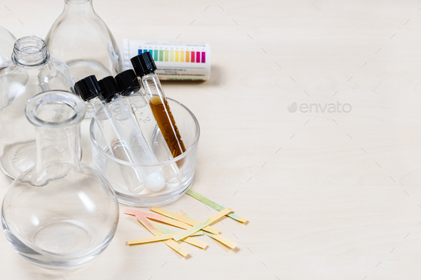 test tubes with various liquids, flasks on table - Stock Photo - Images