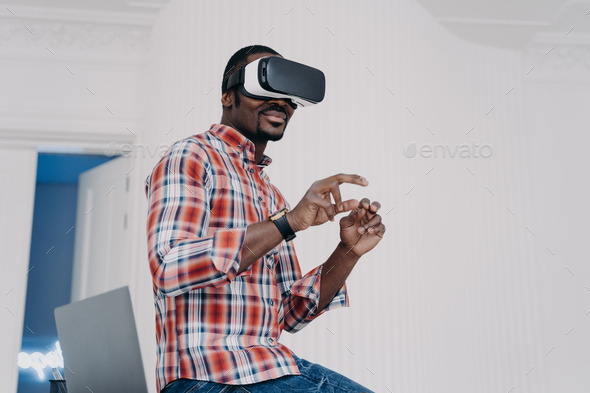 Modern african american man in virtual reality glasses enjoying virtual tour in augmented cyberspace