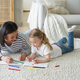Kid girl daughter and mom drawing painting lying on floor carpet together. Children&#39;s education - PhotoDune Item for Sale