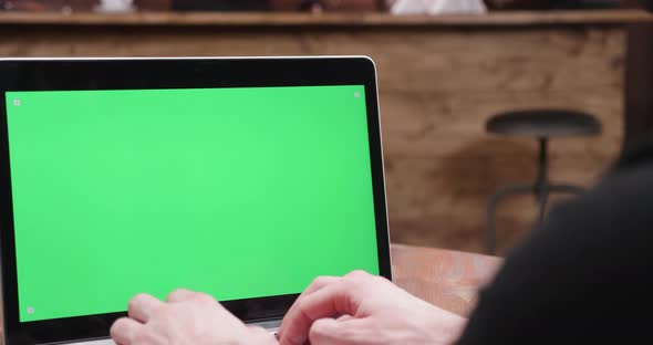 Man Types Fast on a Computer with Green Screen on Display alt