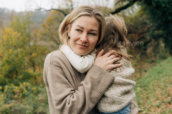 Young pretty mother embracing her little daughter. - Stock Photo - Images