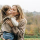 Mom kisses a little charming daughter, holding in her arms. - PhotoDune Item for Sale