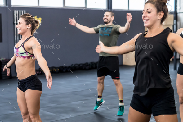 group of people training gym cross fit doing jumping jacks