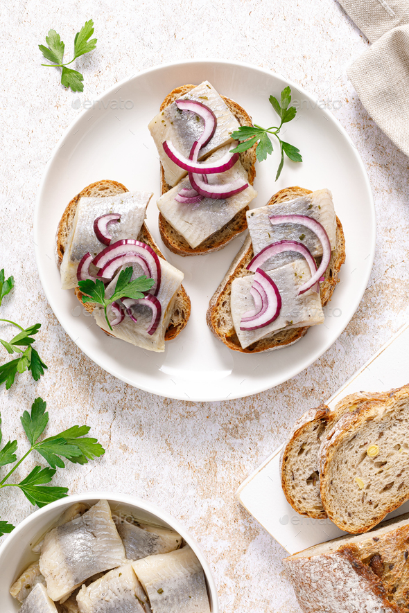 Herring sandwich. Open sandwiches with whole grain bread, herring and onion. Top view - Stock Photo - Images