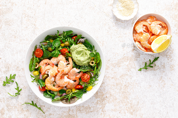 Shrimp and leafy vegetables salad with tomato, bell pepper, olive and avocado sauce. Top view - Stock Photo - Images