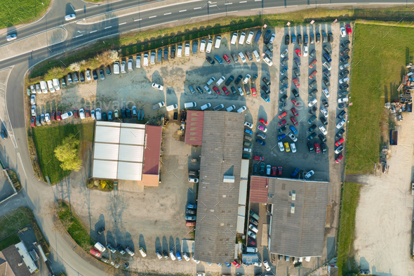 Aerial view of many colorful cars parked on dealer parking lot for sale