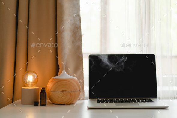 Aroma oil diffuser in work place, laptop and home decor - Stock Photo - Images