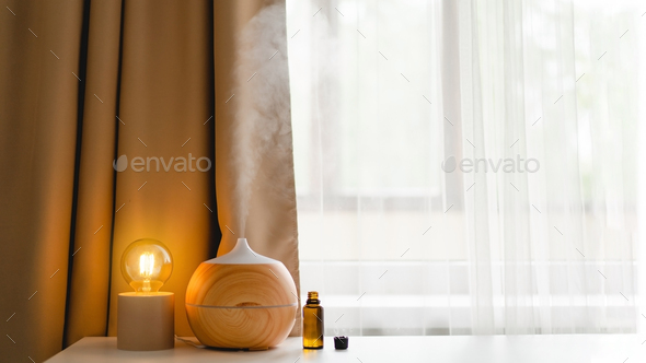 Aromatherapy concept. Aroma oil diffuser on the table against the window. - Stock Photo - Images