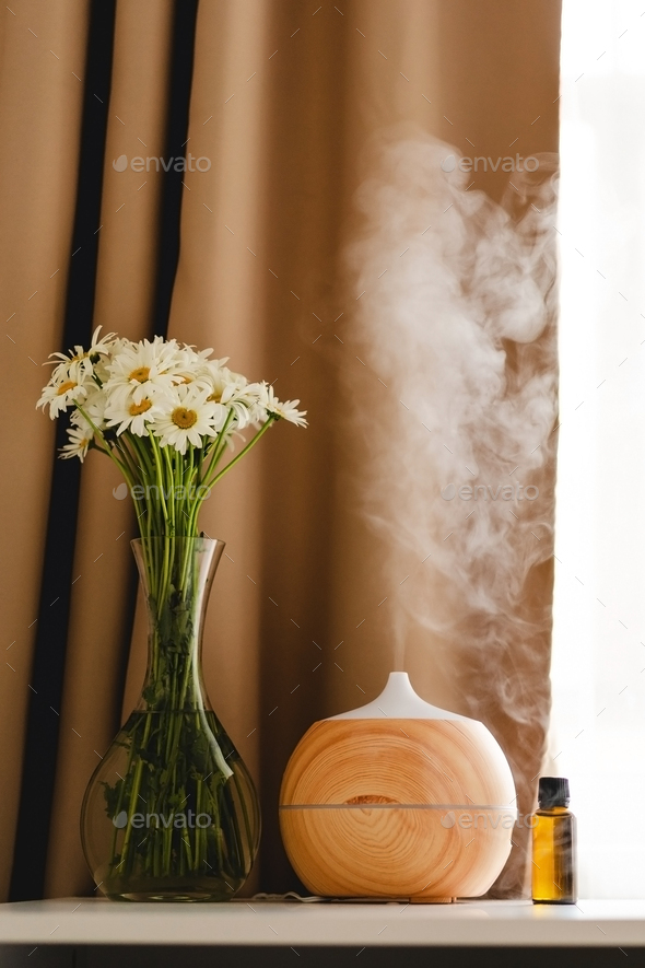 Aromatherapy concept. Aroma oil diffuser on the table against the window. - Stock Photo - Images