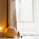 Aromatherapy concept. Aroma oil diffuser on the table against the window. - PhotoDune Item for Sale