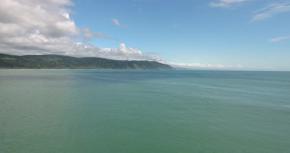 Flying backwards over coastline in northern California near Crescent City harbor