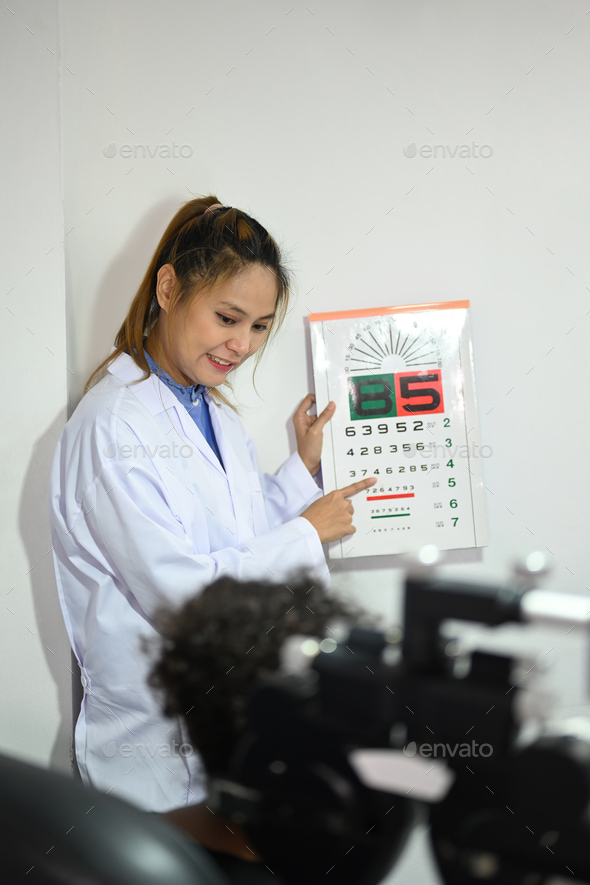 Shot of ophthalmologist checking child eyesight with ophthalmology measurements letters.
