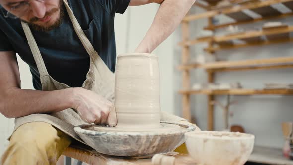 Close Up of Male Potter Forming Handmade Vase on Pottery Wheel at Studio Slow Motion alt