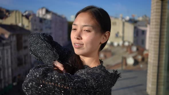 Carefree Beautiful Asian Woman with Teeth Braces Smiling Admiring Urban City on Sunny Day alt