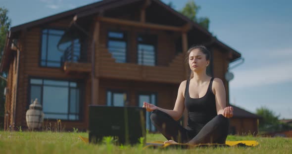 Young Girl Watches Yoga Lessons Online and Meditates alt