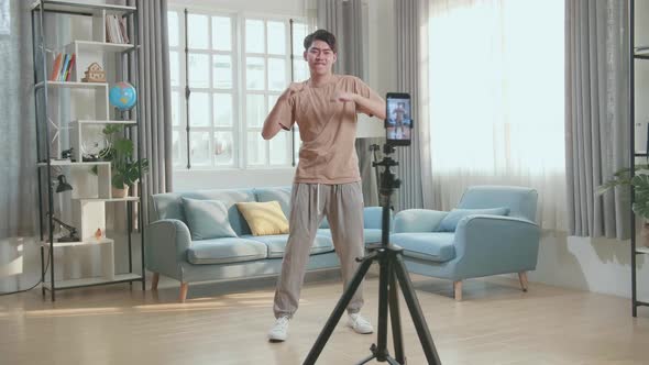 Asian Man Dancing While Shooting Video Content For Social Networks With A Smartphone Camera alt